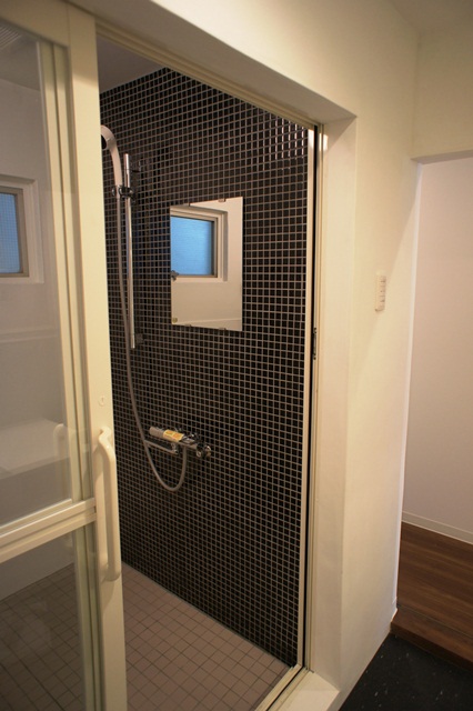 浴槽を取り払ってシャワールームに。比較的大きな空間なので後で浴槽を供える事も可能。黒のモザイクタイルがアクセントになって良い。