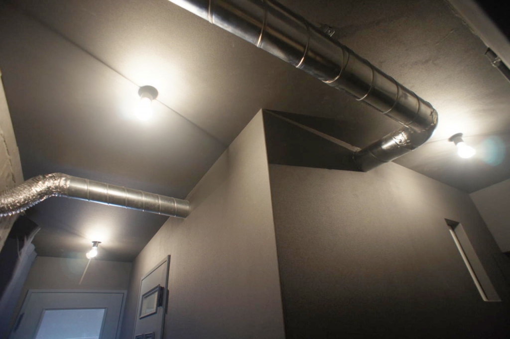 ローカ部分の天井、シャワールームの換気扇にキッチンの換気扇のダクトもむき出し。隠すこともできるが余分な壁も増える。敢えて見せることでこの部屋のアクセントになっている。